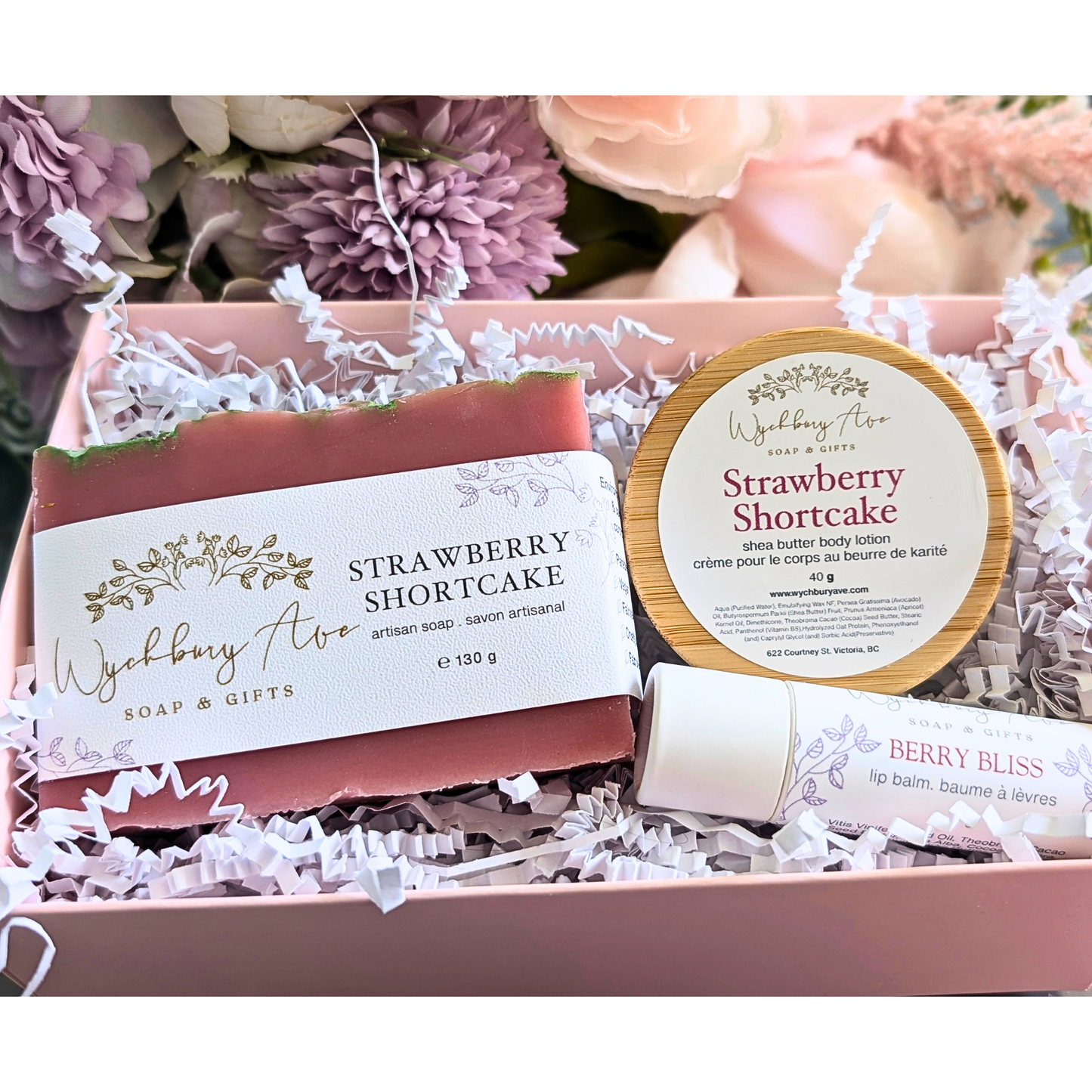 Wyethbury Aloe Strawberry Shortcake soap, lotion, and lip balm set with flowers in the background