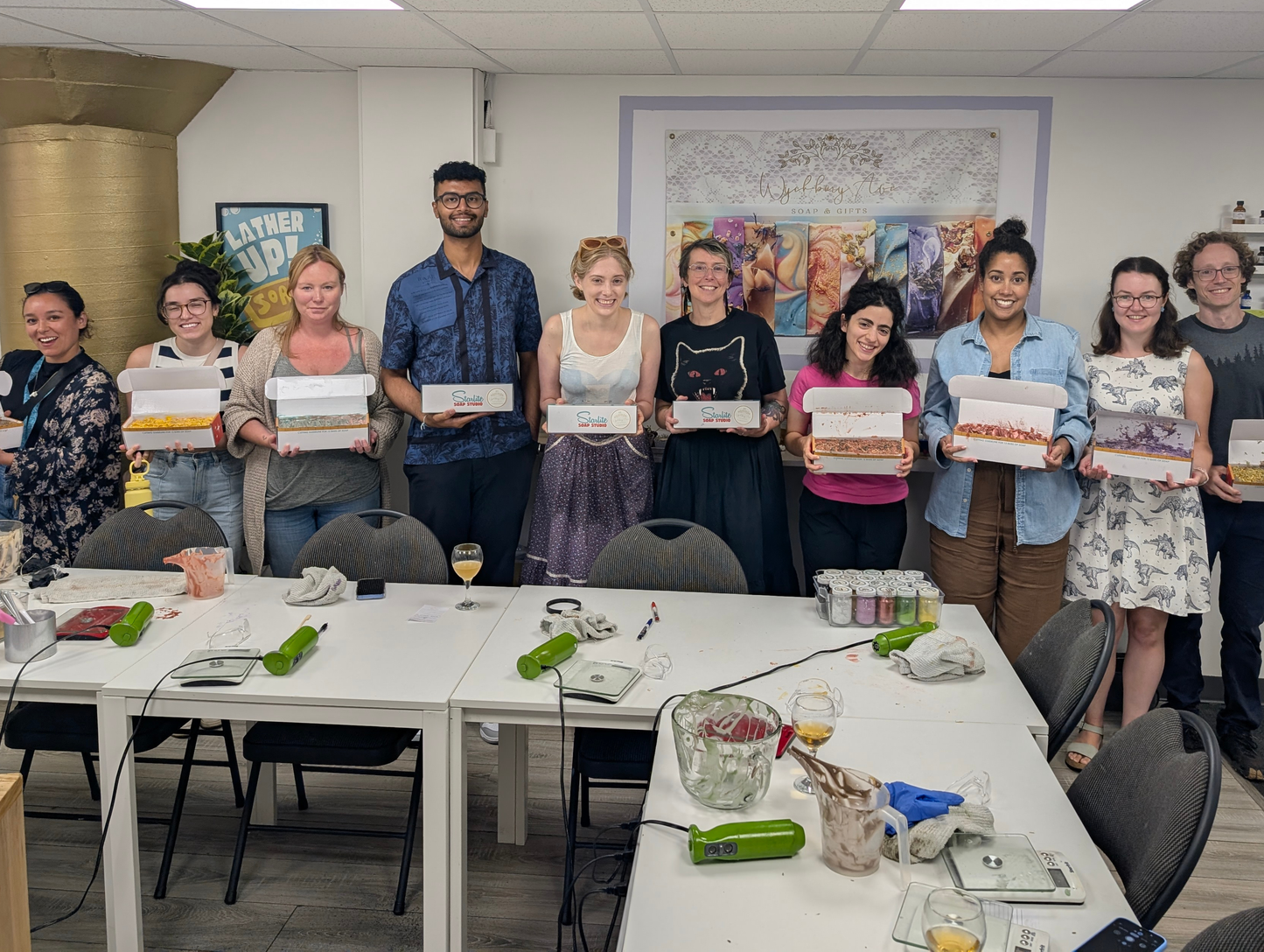 Group of people showing off their soaps in a soap-making studio