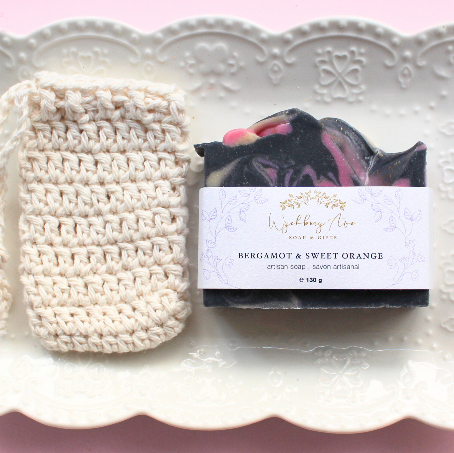 cotton soap saver bag next to bergamot sweet orange bar soap on a white plate
