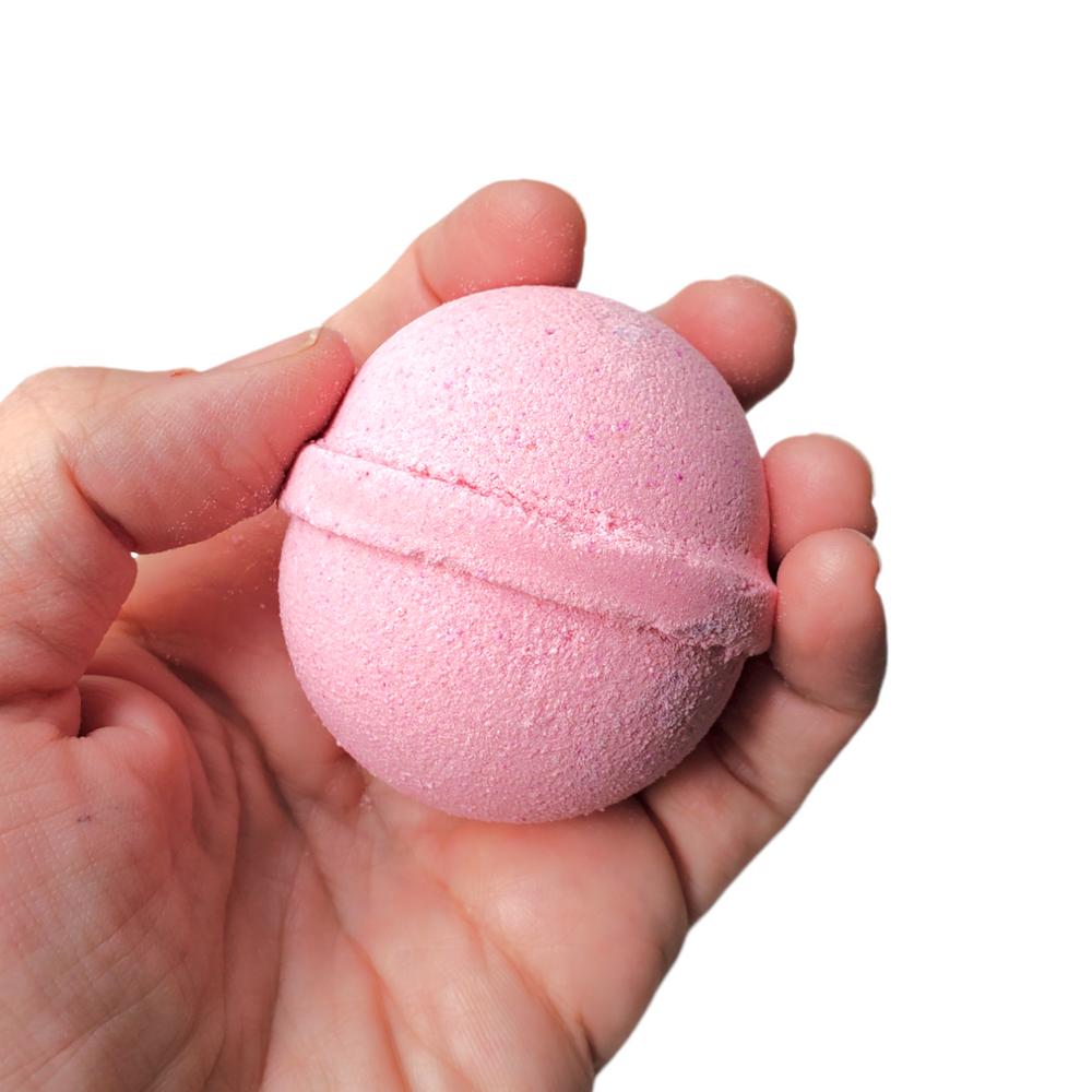 pink cotton candy bath bomb held in hand